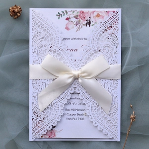 Detailed laser cut lace wedding invitation with ribbon and floral insert card detail