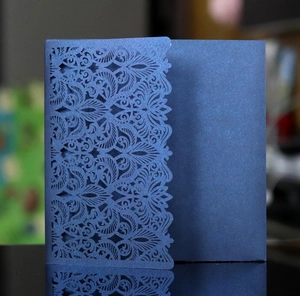 Navy blue pearlescent laser-cut wedding invitation card with intricate floral pattern