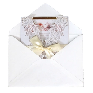 Elegant white laser-cut wedding invitation with pink rose floral inner card and ribbon