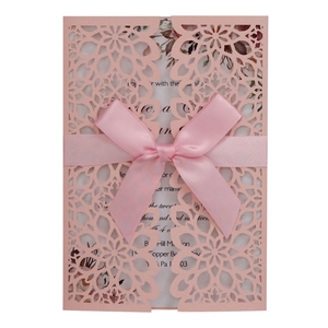 Elegant pink laser cut wedding invitation card with floral pattern and satin ribbon bow