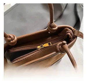 Close-up of brown patchwork bucket bag showing interior lining and gold metal zipper