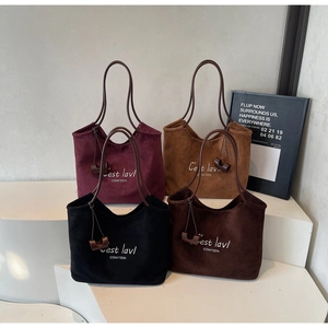 Detailed display of four tote bags in suede material with white artistic lettering