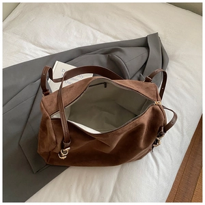 Detailed top view of brown suede tote bag featuring premium metal buckle and gray lining