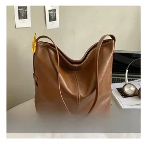 Détail du sac hobo en cuir marron brillant avec boucle en métal doré élégante