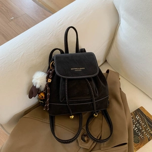 Close-up of black leather drawstring backpack with white stitching and M pendant detail