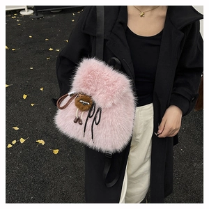 Detail eines rosa Kunstpelz Rucksacks mit schwarzem Kordelzug und süßem Anhänger