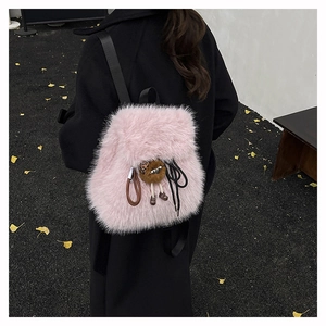 Detail eines rosa Kunstpelz-Rucksacks mit weicher Textur und Plüschtier-Anhänger