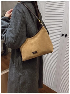 Dettaglio della borsa tote in pelle scamosciata color cammello con finiture marroni