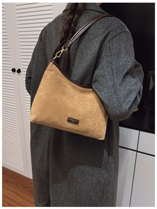 Dettaglio della borsa tote in pelle scamosciata con finiture in pelle e gancio dorato
