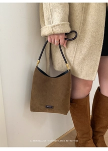Close-up of brown suede tote bag with black slim handles and NO FILTER gold brand lettering