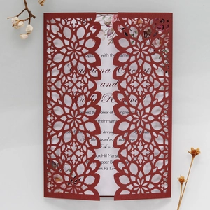 Detail of laser-cut wedding invitation with hollow floral pattern and floral insert card