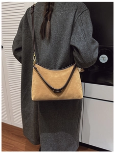Dettaglio borsa tote in camoscio cammello con profili in pelle marrone e fibbia oro