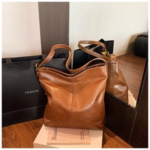 Détail du sac cabas marron avec coutures contrastées blanches et cuir synthétique brillant