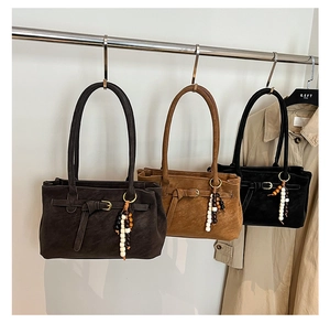 Three vintage suede tote bags in brown, tan, and black with beaded tassels