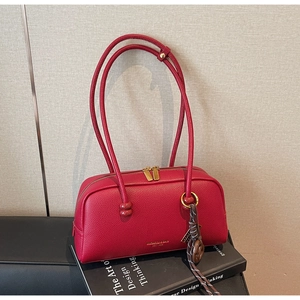 Détails du sac bowling en cuir rouge avec fermeture éclair dorée et nœud tressé