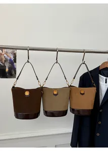 Detailed view of color-block suede bucket bags with leather base and gold hardware