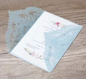 Detailed laser-cut wedding invitation in light blue lace with floral inner card inserts