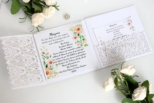 Detail of laser-cut white wedding invitation with floral insert and elegant roses