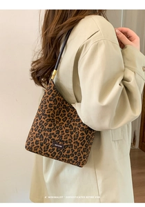 Detail of leopard print underarm bag with NO FILTER label and metallic hardware accents