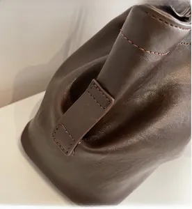 Détail des coutures précises et de la texture du cuir lisse sur ce sac cabas marron