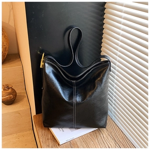 Détail du sac cabas en cuir noir avec surpiqûres blanches et boucle dorée chic