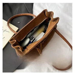 Macro view of the large capacity interior with zipper pocket in a brown suede bag