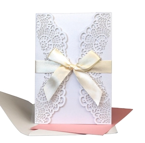 White laser cut wedding invitation card with pink insert and cream ribbon bow set