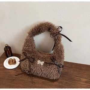 Borsa a mano in peluche marrone con fibbia a farfalla argentata e nastri decorativi