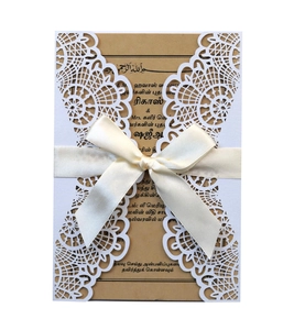 Nahaufnahme der lasergeschnittenen Hochzeitseinladung mit beige Satinschleifen-Detail