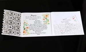 Detail of laser-cut white wedding invitation with floral insert and pocket sleeve