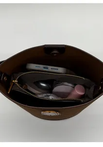 Internal view of brown suede bucket bag showing spacious capacity with a zipper pocket