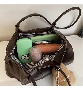 Vue de dessus de l'intérieur du grand sac cabas montrant la doublure rayée et le fermoir magnétique