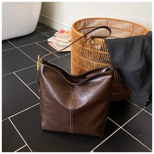 Détail du sac cabas en similicuir marron foncé brillant avec couture verticale blanche
