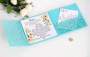 Detail of laser-cut Tiffany blue wedding invitation with elegant floral print insert