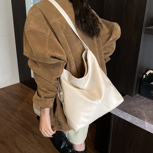 Mannequin portant un grand sac cabas en cuir blanc crème au fini lisse élégant