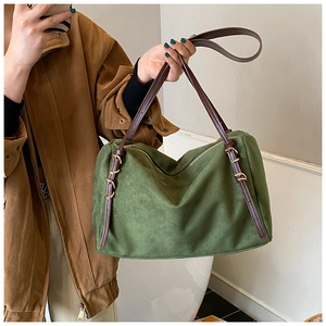 Detail of retro green suede shoulder bag with brown leather straps and gold zipper