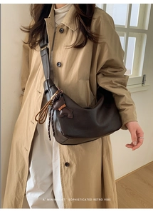 Deep brown leather half-moon crossbody bag with cute bear charm and wide strap detail
