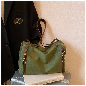 Detail showing green suede texture and brown leather strap with gold hardware on bag