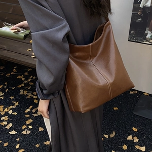 Vue détaillée du sac cabas en cuir marron brillant avec surpiqûres blanches contrastées