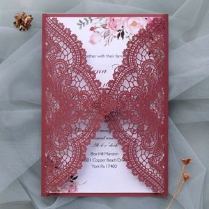 Detail showing burgundy laser-cut lace wedding invitation with floral inner card