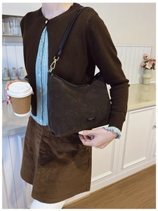 Dettaglio della borsa Hobo in pelle scamosciata marrone con finiture in pelle su modella