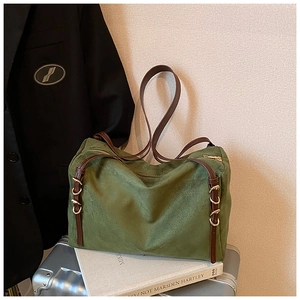 Detail of green suede tote bag with brown leather straps and adjustable gold buckles