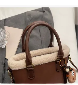 Détail du sac à main en similicuir marron et bordure en polaire avec pendentif ours