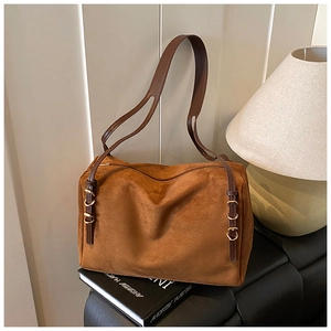 Detailed view of brown suede shoulder bag with retro gold hardware and leather strap