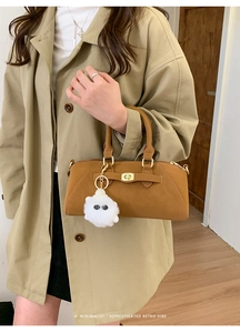 Borsa a mano marrone in pelle con chiusura girevole dorata e charm a forma di mostro