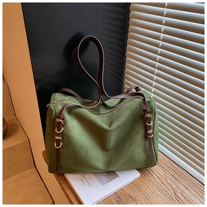 Detailed close-up of dark green faux suede tote with leather straps and gold metal buckle