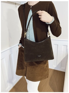 Borsa tote in camoscio marrone indossata da una modella, forma a trapezio