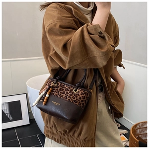 Detail of vintage leopard print bucket bag with leather texture and decorative beads