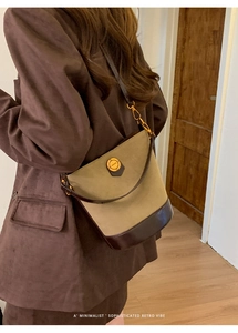 Detail view of vintage bucket bag featuring khaki canvas and brown leather stitching