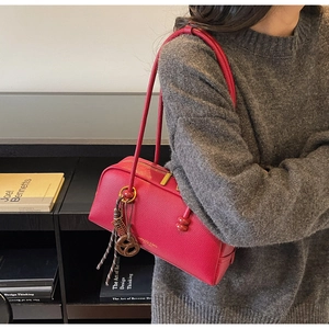 Sac bowling magenta en cuir grainé avec longues bandoulières et ruban décoratif